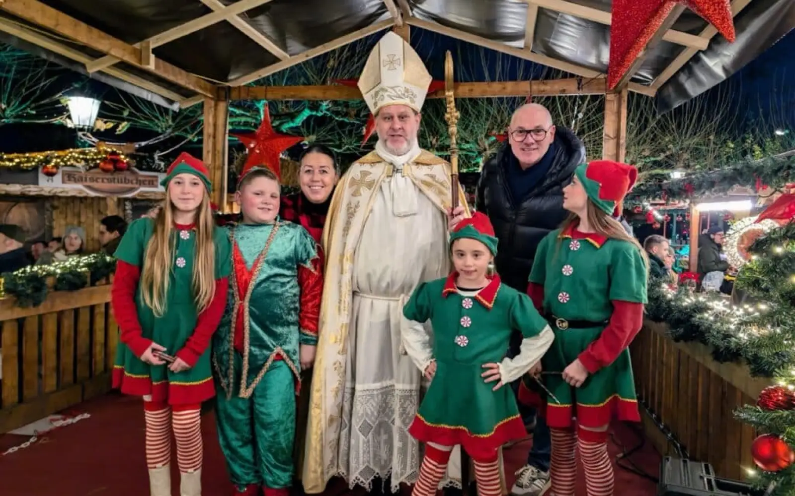 Der Nikolaus brachte gemeinsam mit seinen Elfen Schokolade und Zuckerstangen. Im Hintergrund stehen Stefanie und Nils Hermann, die Betreiber des Kaiserswerther Winterdorfs. Foto: ah
