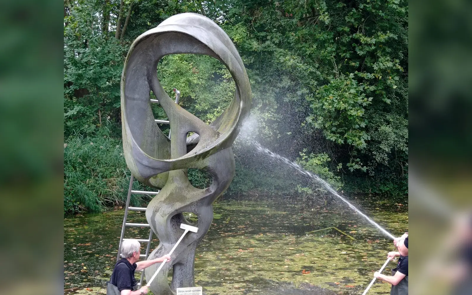 Mitglieder der Tischgemeinschaft Pastor Jääsch reinigen jährlich die Schneckenplastik im Teich vor dem Aquazoo Düsseldorf. Foto: privat