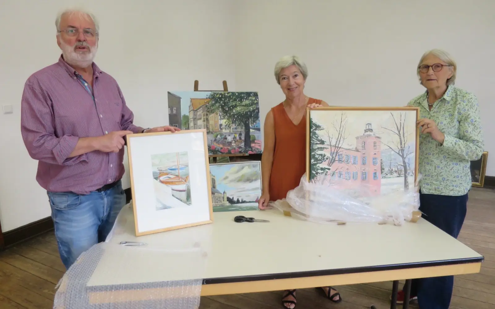 Karl Döhler, Kunsthistorikerin Dr. Barbara Grotkamp-Schepers, Kerstin Döhler, Vorsitzende des Heimat- und Bürgervereins (von links), bei der Vorbereitung der Ausstellung Gustav-Adolf Hornscheidt: „Meine Welt in Bildern“. Foto: hs