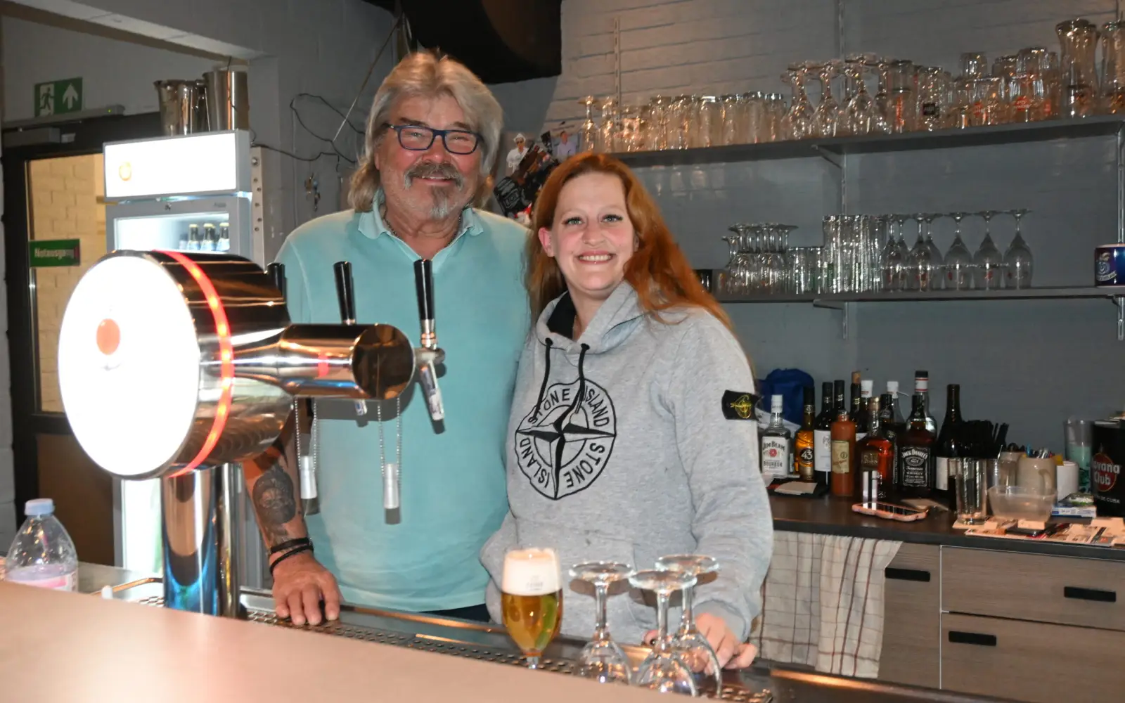 Werner Pusch, hier mit Mitarbeiterin Jasmin Jacek, freut sich auf viele Menschen in seinem beliebten Vereinslokal „Werner´s GSG-Treff“. Es liegt an der Grenze zwischen Großenbaum und Buchholz. Foto: sam