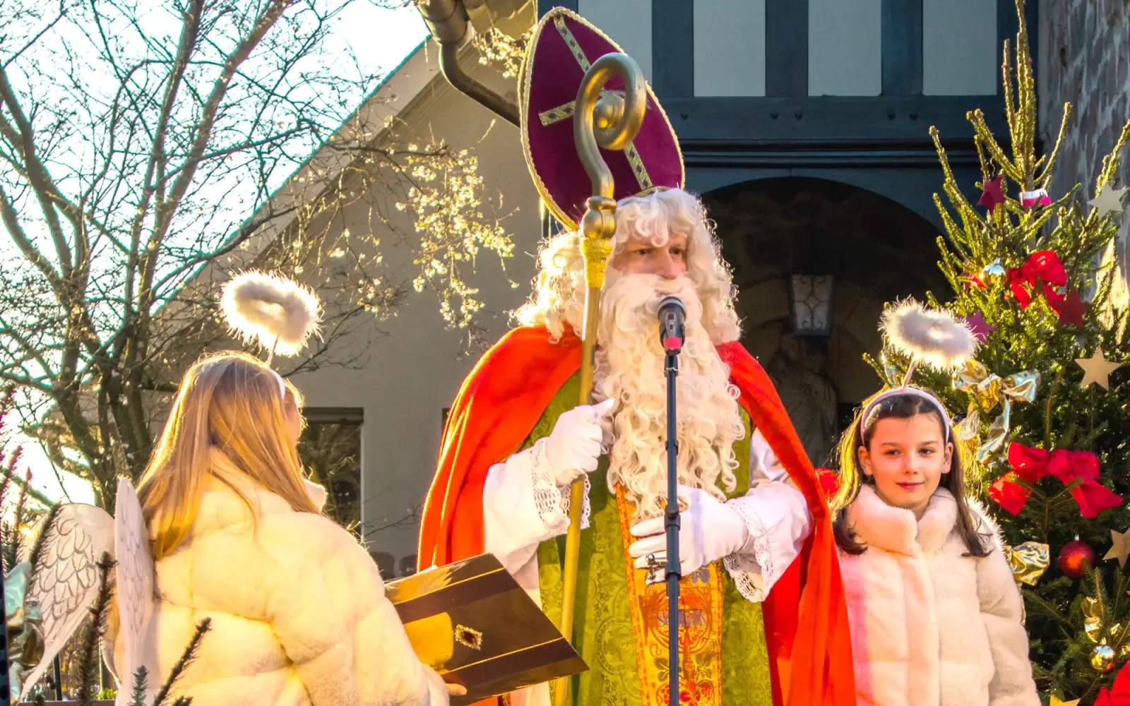 Der Nikolaus, begleitet von seinen zwei Engelchen, bei seiner nachmittäglichen Ansprache, insbesondere natürlich an die Kindergartenkinder. Foto: vj
