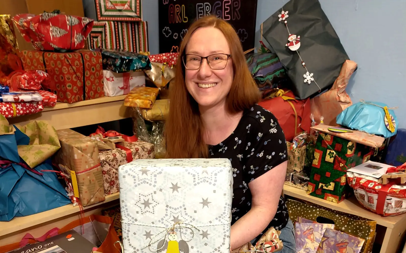 Jugendleiterin Yvonne Queder präsentiert einen Teil der 120 Geschenkpakete der Wunschbaumaktion. Foto: trinitatis-duisburg.de