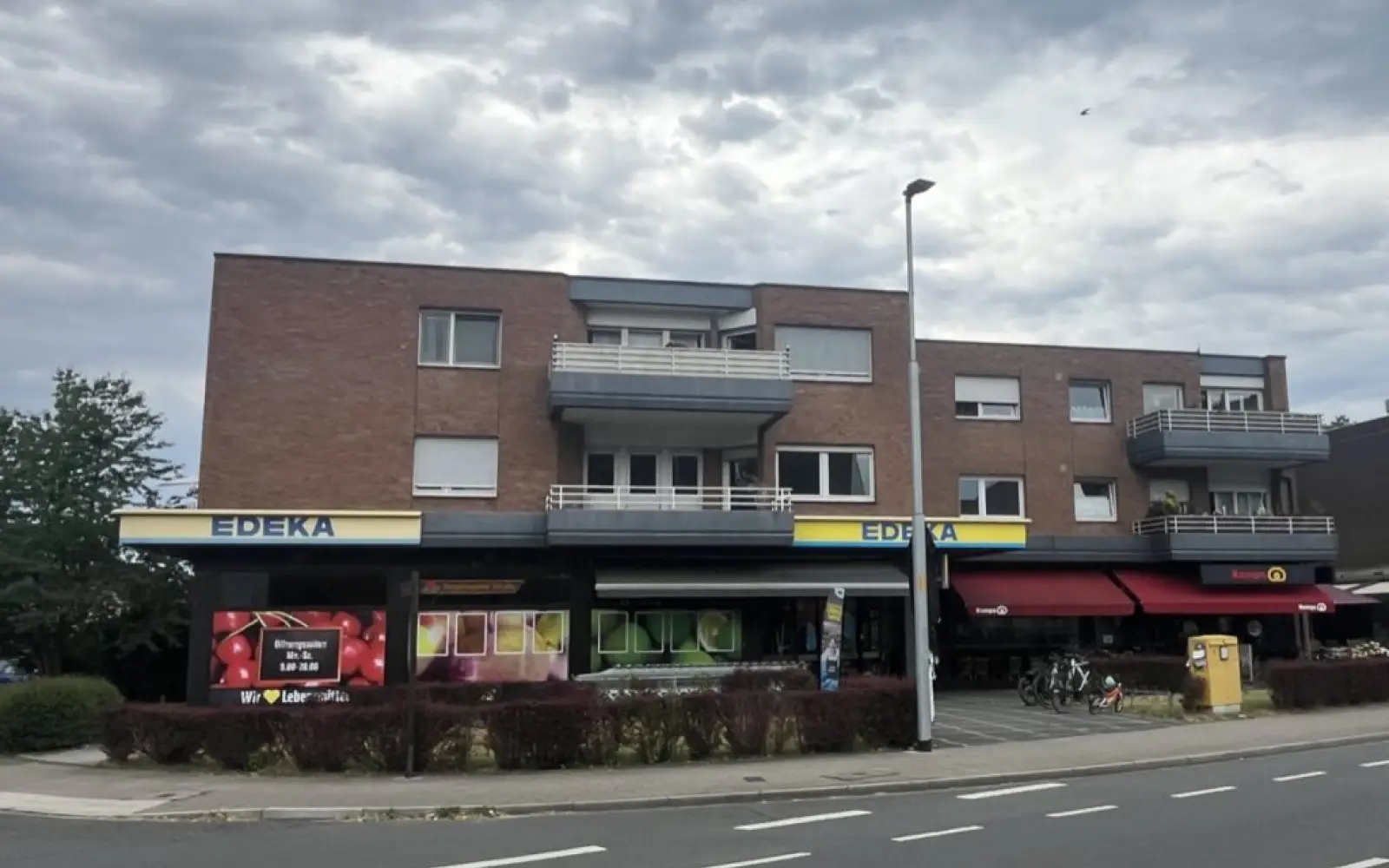 An der Angermunder Straße 40 verkauft heute ein EDEKA-Markt, wo um den Jahrtausendwechsel im SPAR-Markt Gödde & Wuff die anfangs als „Kinderpost“ verspottete Postfiliale eröffnete. Vom früheren Poststandort blieb nur der gelbe Briefkasten (Aufnahme von 2026).
