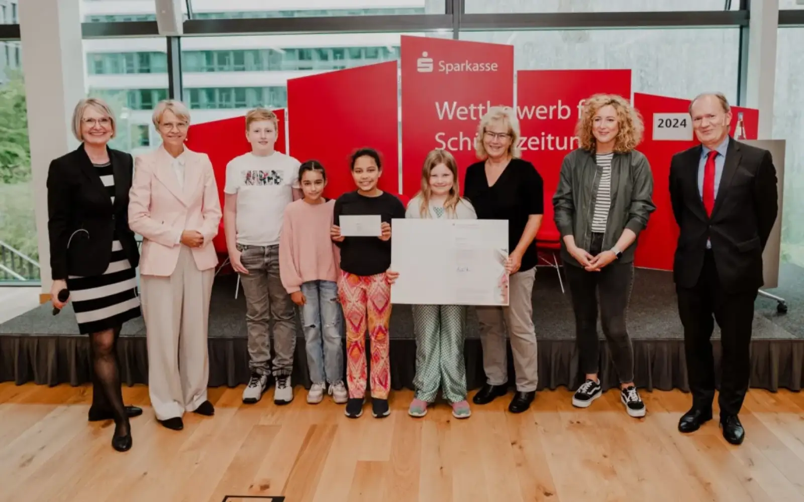 Schulministerin Dorothee Feller (2. von links) und RSGV-Präsident Michael Breuer (rechts) gratulierten einigen Teilnehmenden der Rahmer Schülerzeitungs-AG mit ihrer Leiterin Sabine Merz (3. von rechts). Die „Flinke Feder“ wird von Louisa Zeunert layoutet (2. von rechts). Durch die Feierstunde führte Margareta Rieck. Foto: RSGV