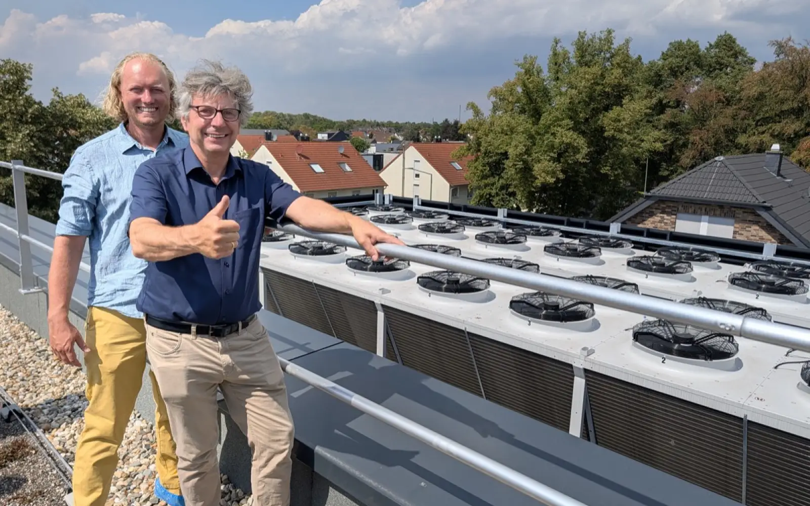 Die Rückkühler der Wärmepumpen auf dem Dach sind viermal so groß gebaut wie nötig und dadurch so leise, dass die Nachbarschaft von den Anlagen nichts hört. Die Haustechnik planten (von links): Christian von Schwartz und Jörn Kaluza vom Aachener Ingenieurbüro INCO. Foto: ah