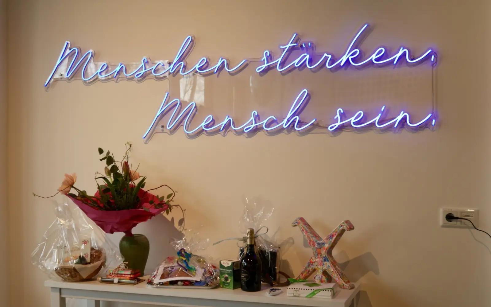 Ein schöner Leitspruch steht in Leuchtschrift hinter der Theke. Foto: cj