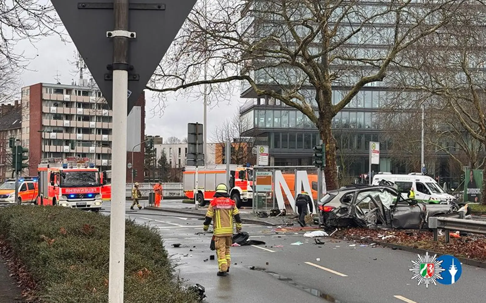 Einsatzkräfte der Feuerwehr und Polizei sichern die Unfallstelle am Verteiler Nordfriedhof. Der stark beschädigte BMW kam an der Bushaltestelle zum Stehen. Foto: Polizei Düsseldorf