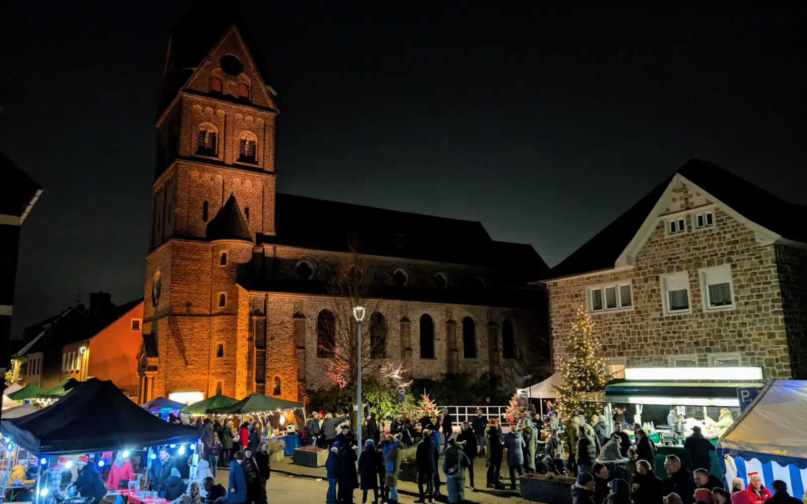 Vor der beleuchteten Kulisse der St. Agnes Kirche genossen zahlreiche Besucher die Atmosphäre auf dem 32. Nikolausmarkt in Angermund. Foto: ah
