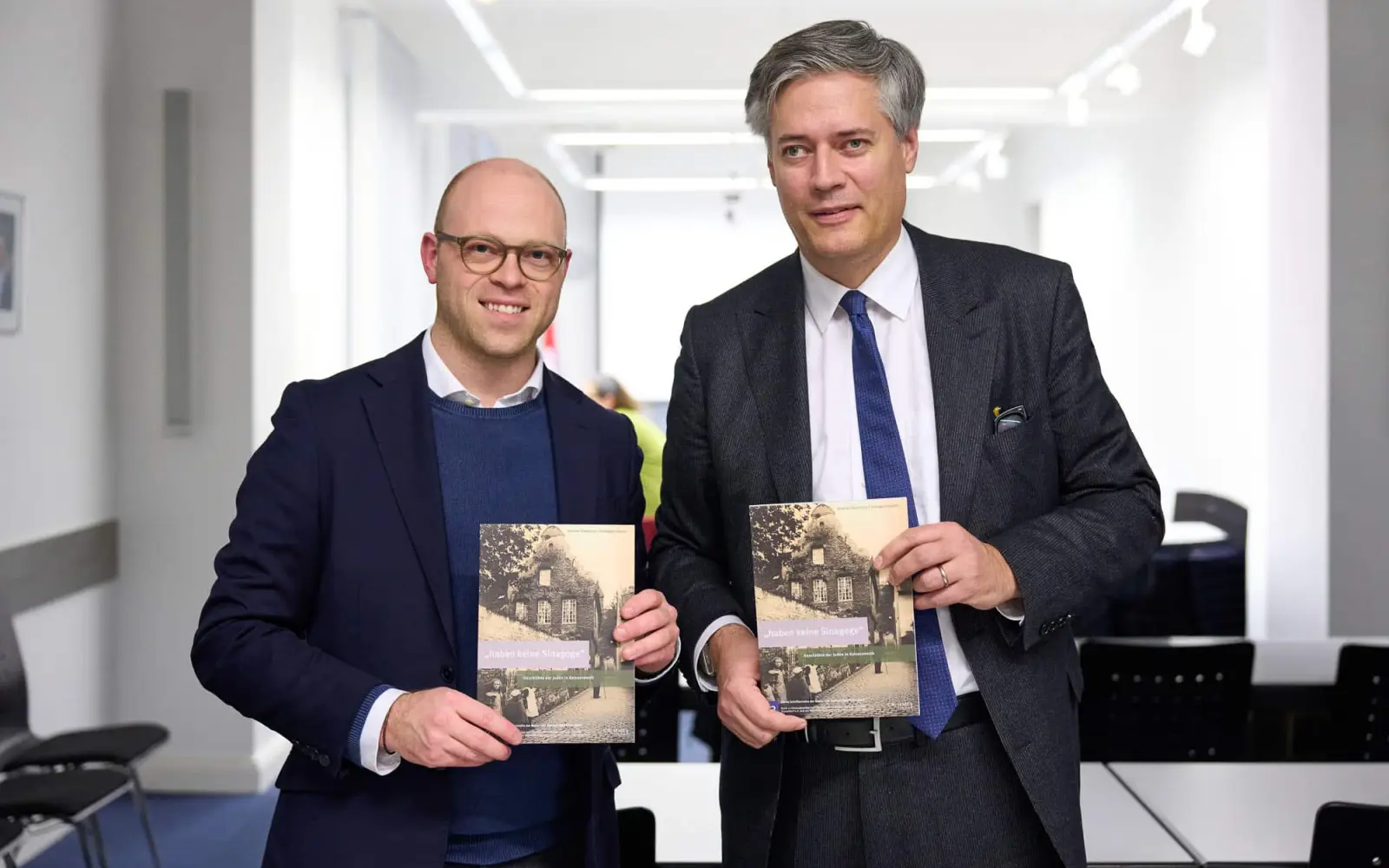 Der 12. Band entstand nach einem entsprechendem Beschluss der Bezirksvertretung 5: Bezirksbürgermeister Benedict Stieber und Autor sowie Leiter der Mahn- und Gedenkstätte Dr. Bastian Fleermann stellten die Publikation vor. Foto: Landeshauptstadt Düsseldorf/Claus Langer