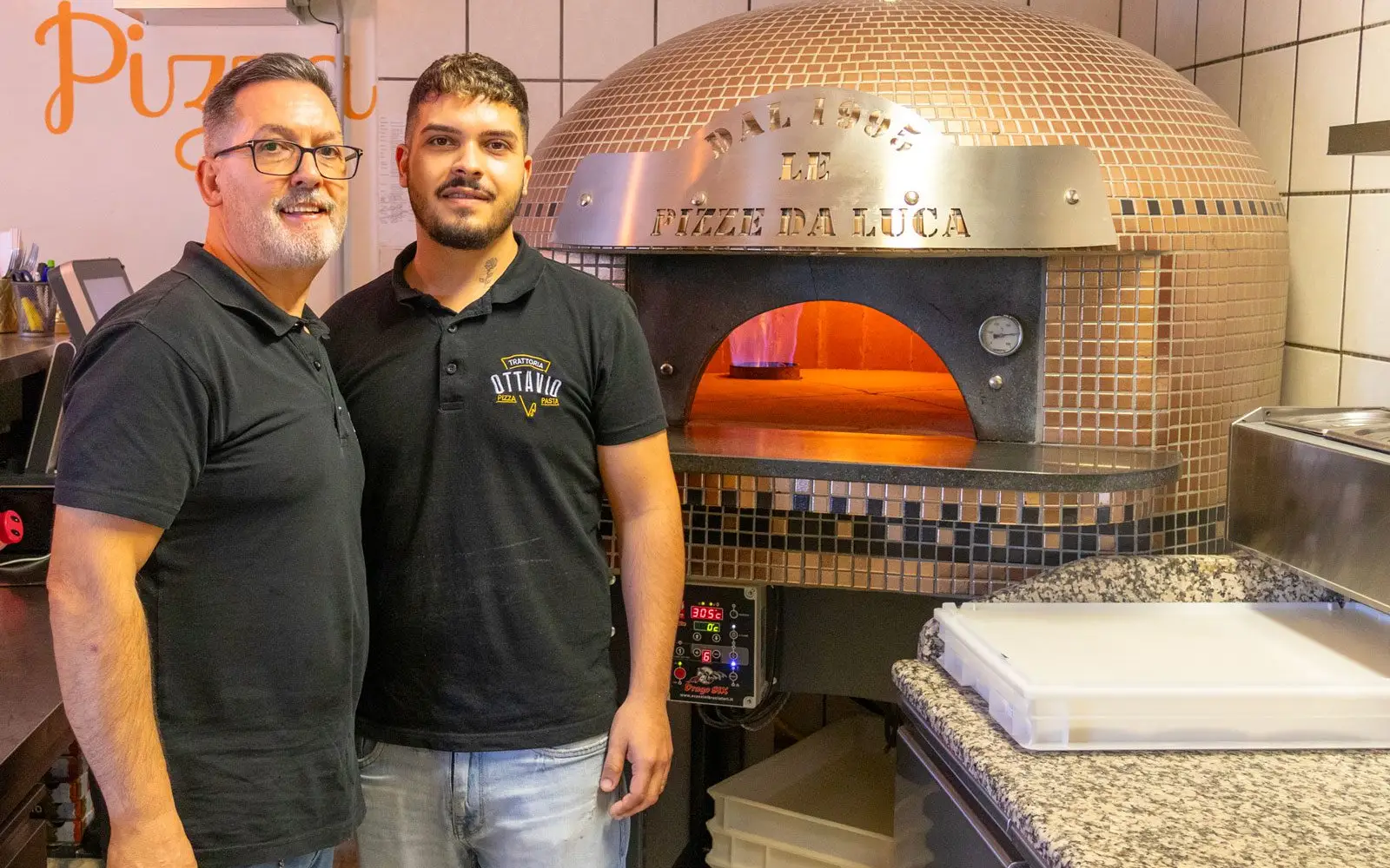 Adriano und Luca Cianciaruso (von links) vor dem neuen Ofen mit dem Schriftzug „Dal 1995 Le Pizze da Luca“. Foto: ah