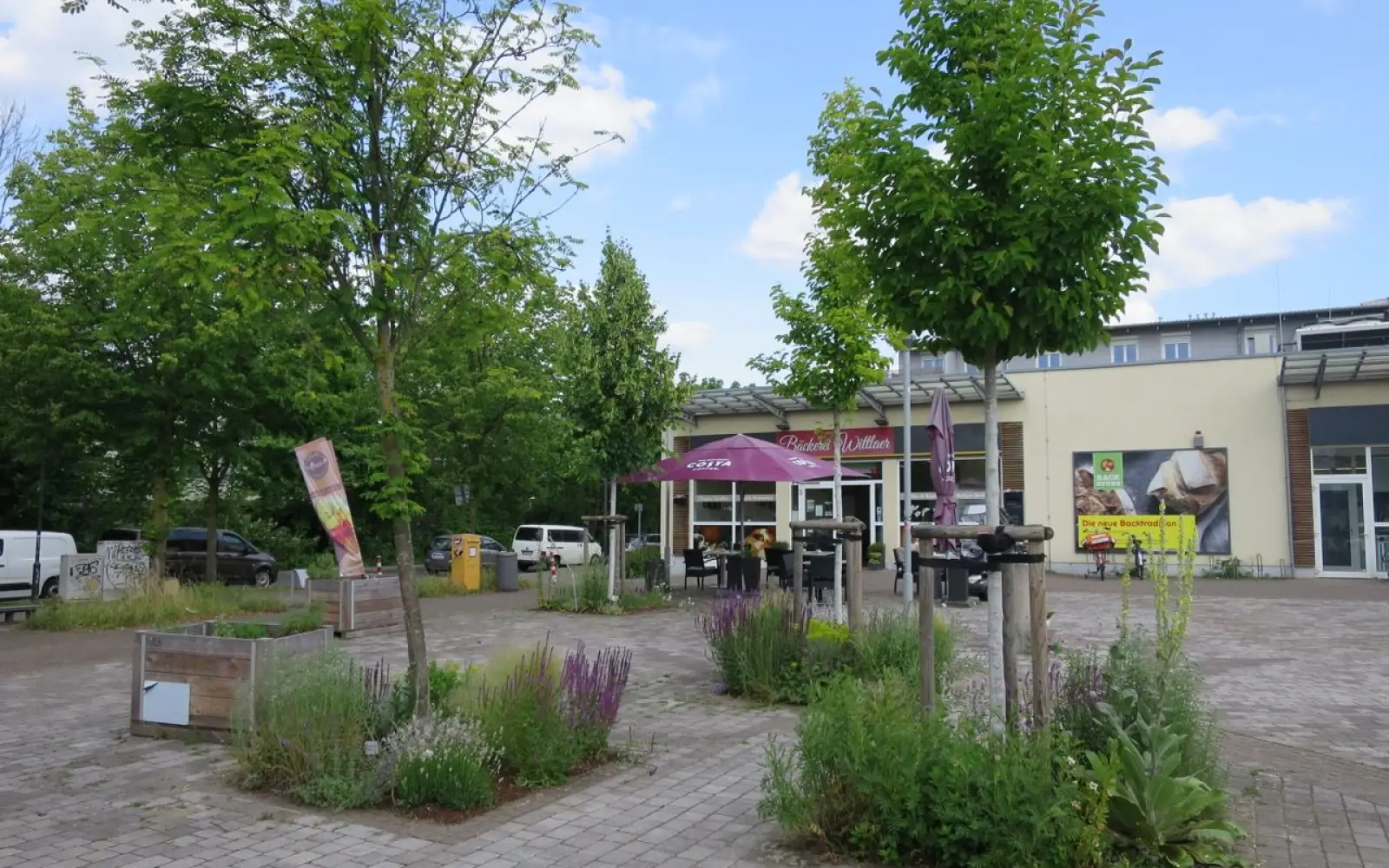 Auf den weitläufigen Hannes-Esser-Platz in Wittlaer-Einbrungen bringt die Außengastronomie der Bäckerei Wittlaer Belebung. Foto: hs