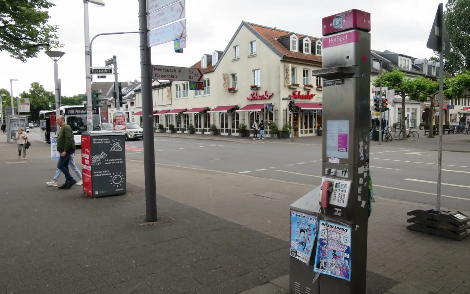Eine unbrauchbare, als Schrott zu bezeichnende Telefonsäule steht auf dem Klemensplatz. Dahinter istdie solarbetriebene Müllpresse zu sehen. Foto: hs