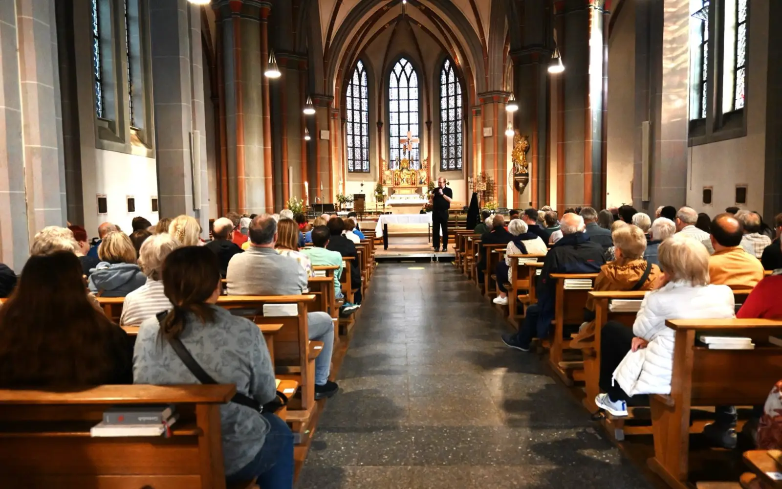 Die Menschen in der voll besetzten Kirche nutzten die Möglichkeit, unter anderem mit Pfarrer Andreas Brocke ins Gespräch zu kommen. Foto: sam