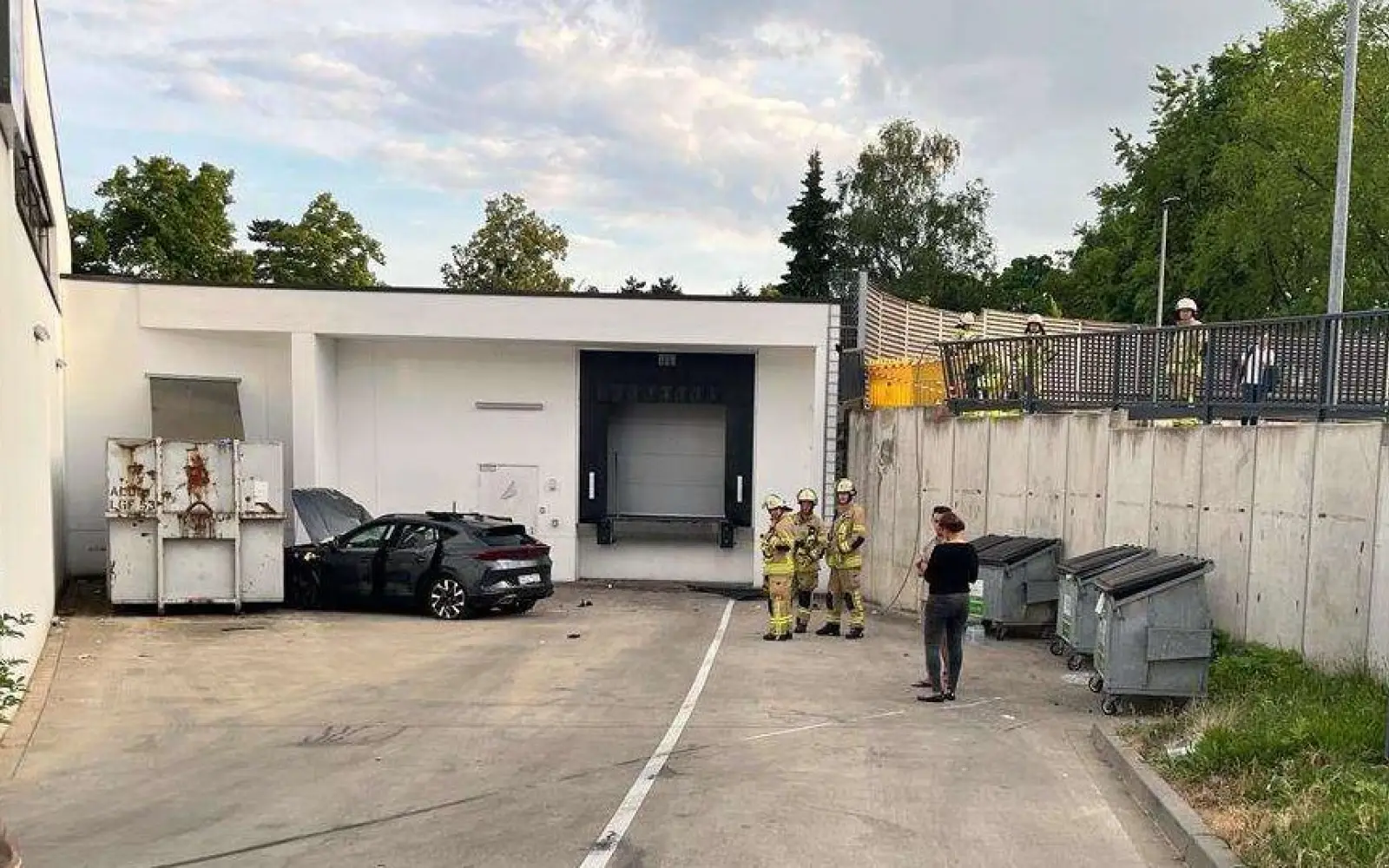 Ein Pkw ist mehrere Meter tief in die Lieferanteneinfahrt eines Discounters in Angermund gestürzt und prallte gegen einen Müllcontainer. Einsatzkräfte der Feuerwehr sicherten die Unfallstelle. Foto: Polizei Düsseldorf