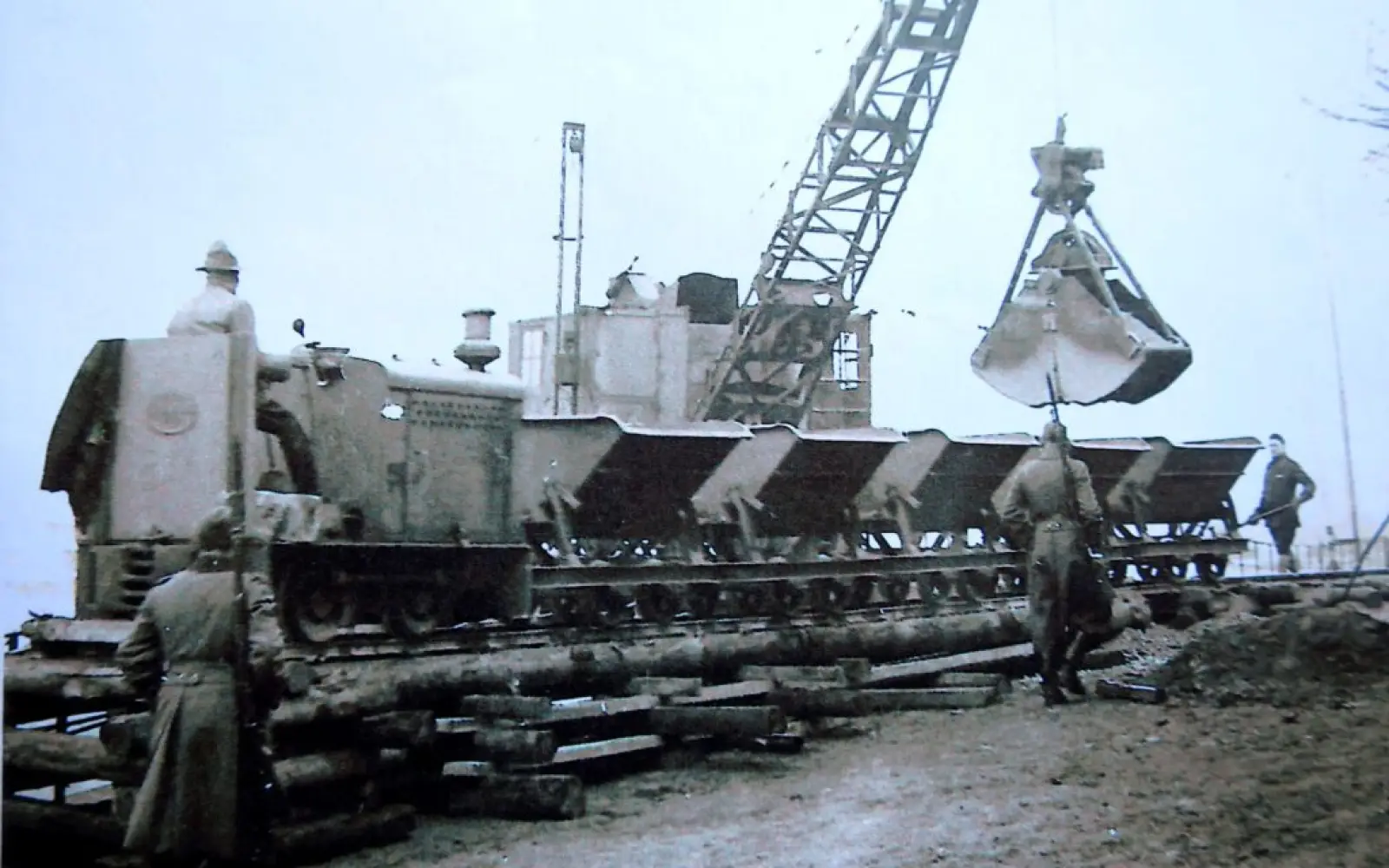 Verladung von Baumaterial auf Loren unter militärischer Bewachung. Archivfoto: Privat