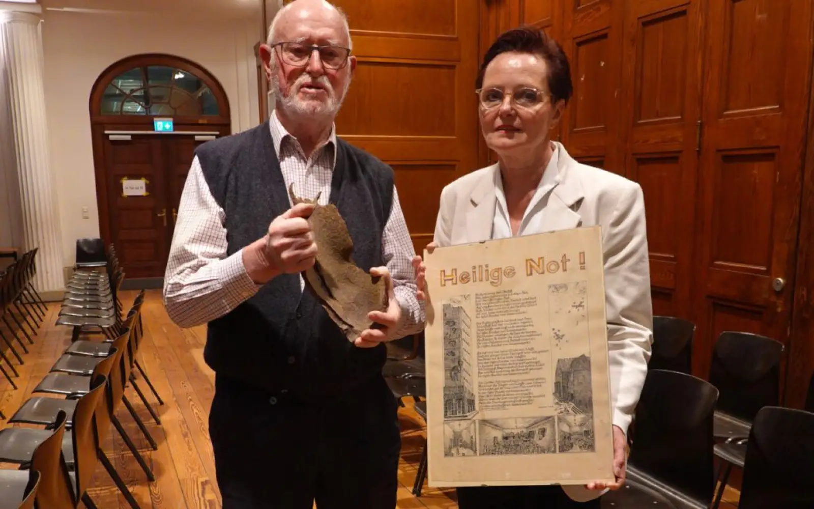 Franz-Josef Vogel mit einem Granatsplitter und Ursula Lösch mit dem Gedenkblatt Kaiserswerth Ostern 1945 – „Heilige Not“. Foto: Karl Döhler