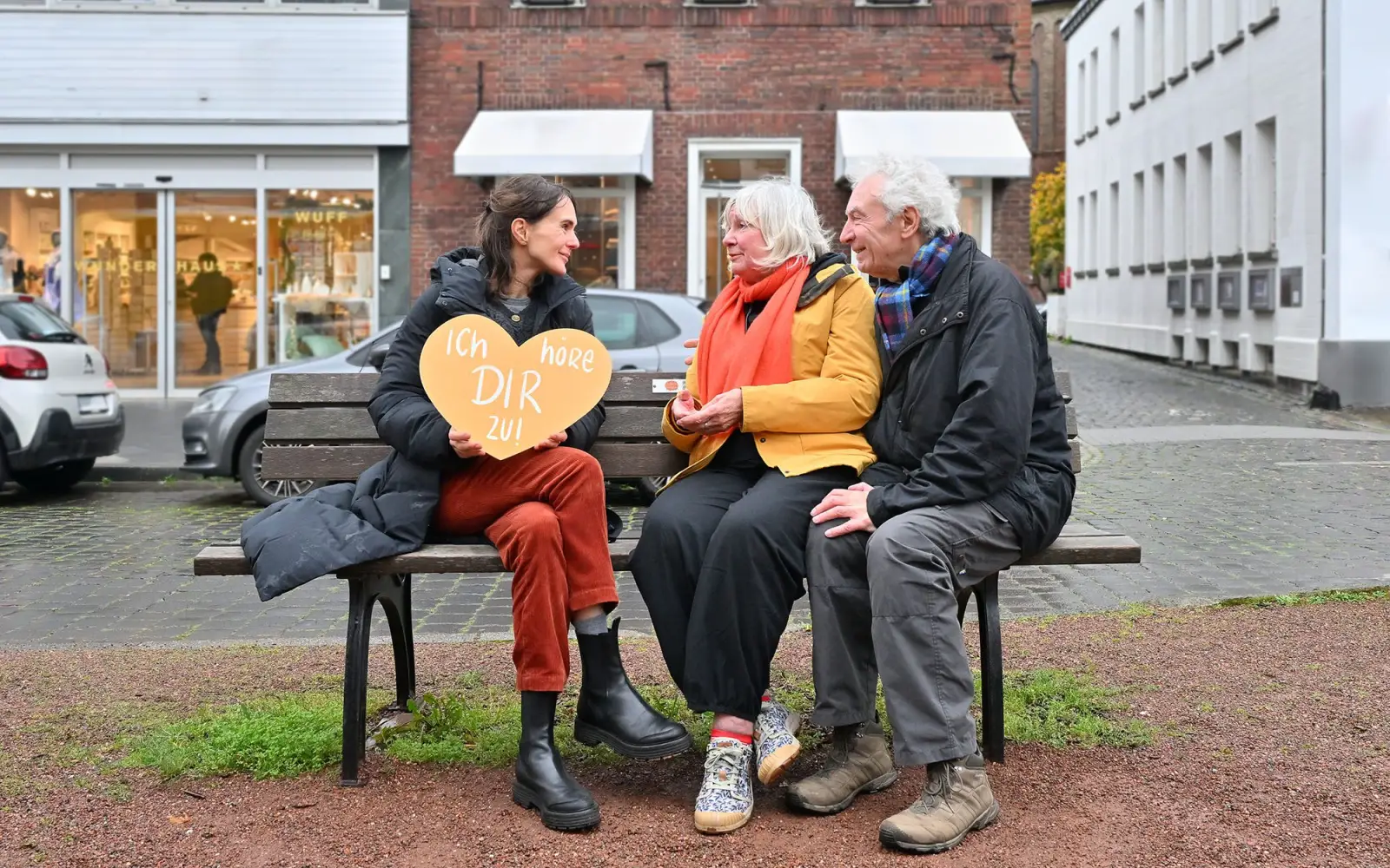 Doris Bast-Forster (Mitte) und Ehrenamtliche begegnen sich auf der Zuhör-Bank am Kaiserswerther Markt. Foto: „zuhören draussen“, Michael Lübke