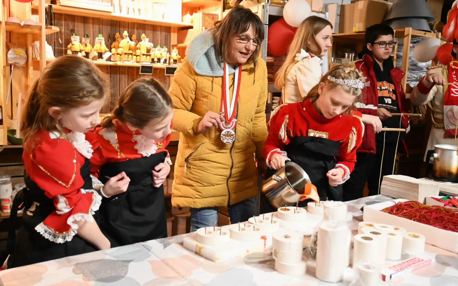 Sabine Lindner erklärt Prinzessin Annie und ihren Paginnen, wie man vorsichtig Kerzen gießt. Foto: sam