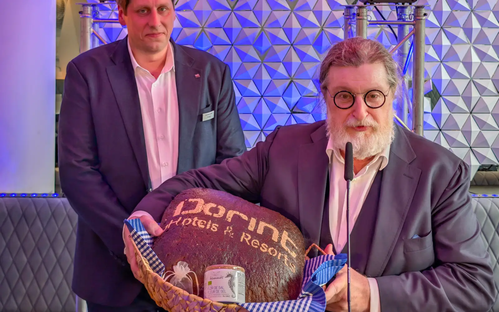 Hoteldirektor Christian Schulte (links) erhält von Dirk Iserlohe Brot und Salz als Willkommensgeschenk. Foto: ah