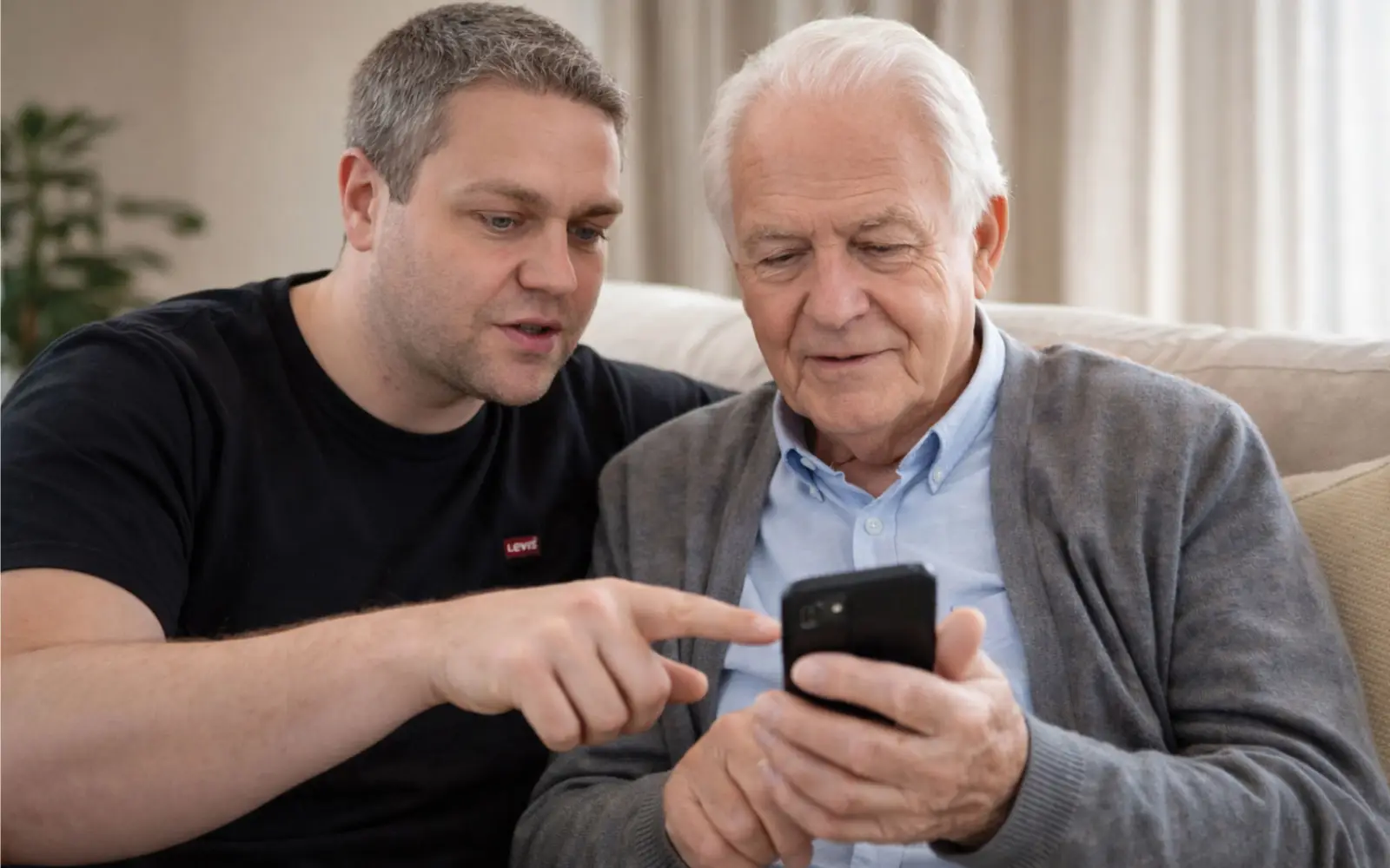 Inhaber Viktor Merger zeigt einem Kunden den Umgang mit dem Smartphone, donnerstags bietet „merger mobile" entsprechende Schulungen im Klemensviertel an. Foto: merger mobile