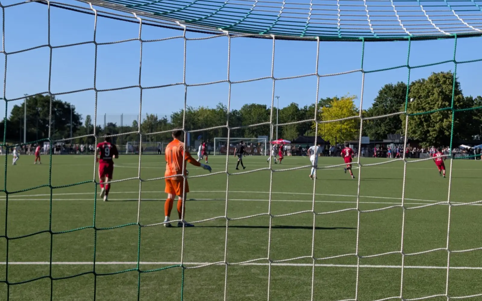 Blick durchs Tornetz auf das Endspiel zwischen den weiß-grünen Spielern des Lohausener SV und dem FC Kosova in Rot. Foto: ah