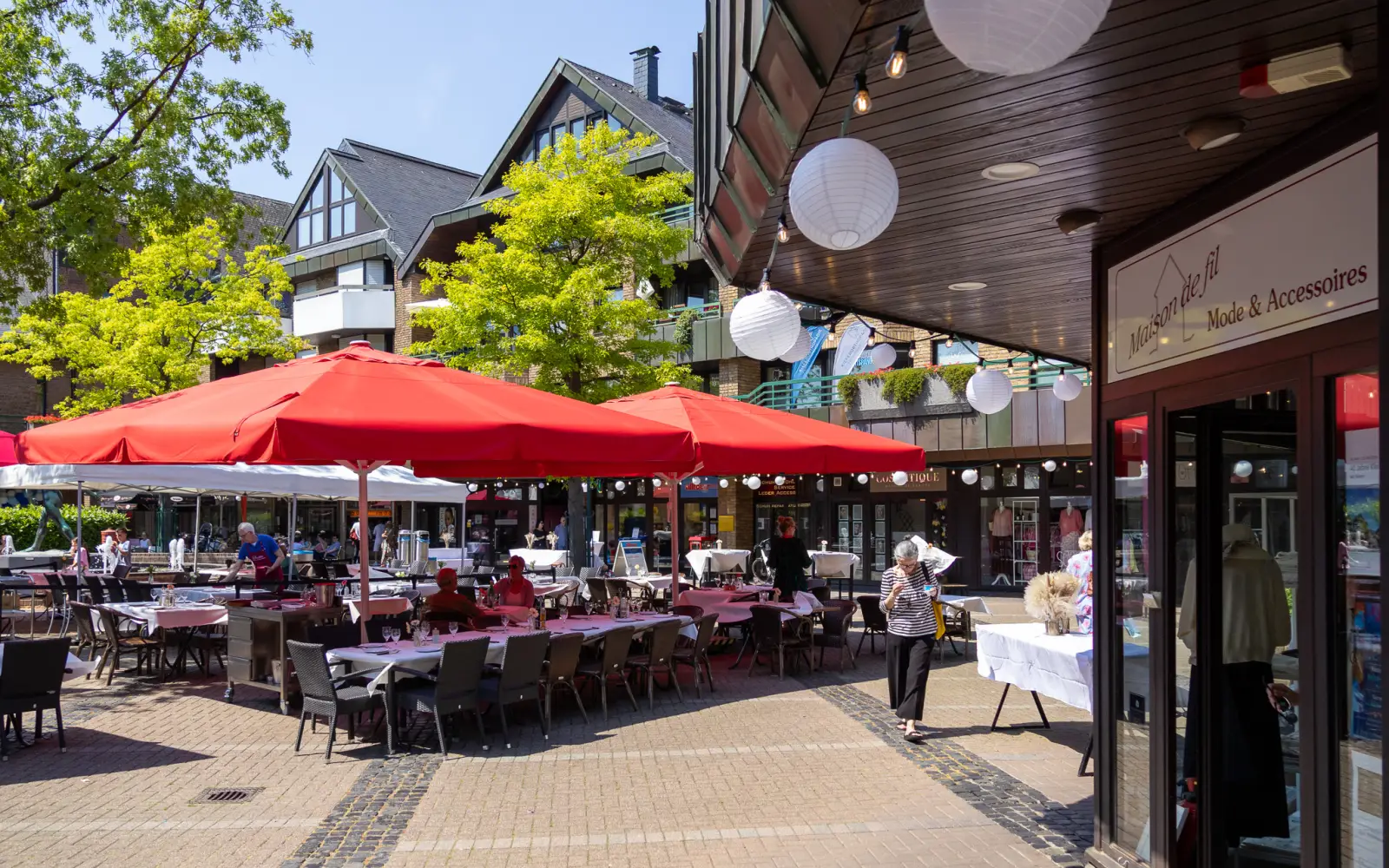 Rote Schirme und weiße Lampions auf dem Klemensplatz. Parallel zur Ausstellung feierten die Geschäftsleute das Jubiläum unter dem Motto „Shoppen, dine & wine". Foto: ah