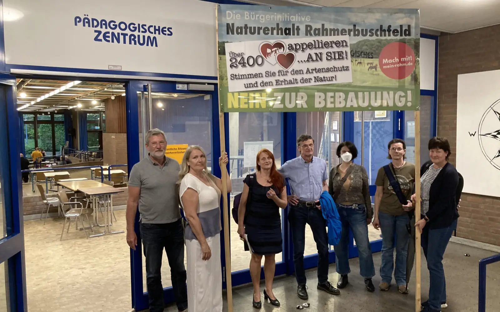 Thomas Anthonj (links) und weitere Vertreter der BI „Naturerhalt Rahmerbuschfeld“ protestierten vor der BV-Sitzung gegen die Pläne für das Neubaugebiet. Foto: sam