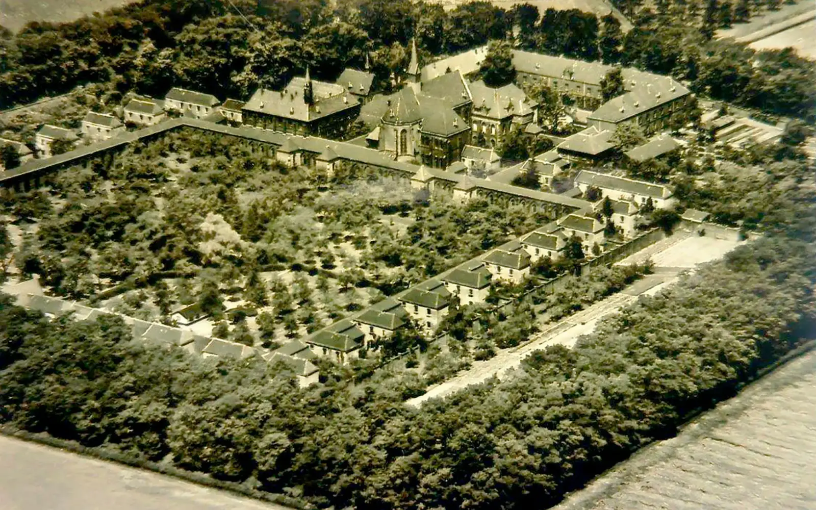 Diese Luftaufnahme zeigt die historische Kartause Hain in Unterrath, umgeben von der weitläufigen Klosteranlage und ihren 10.000 Eichen.