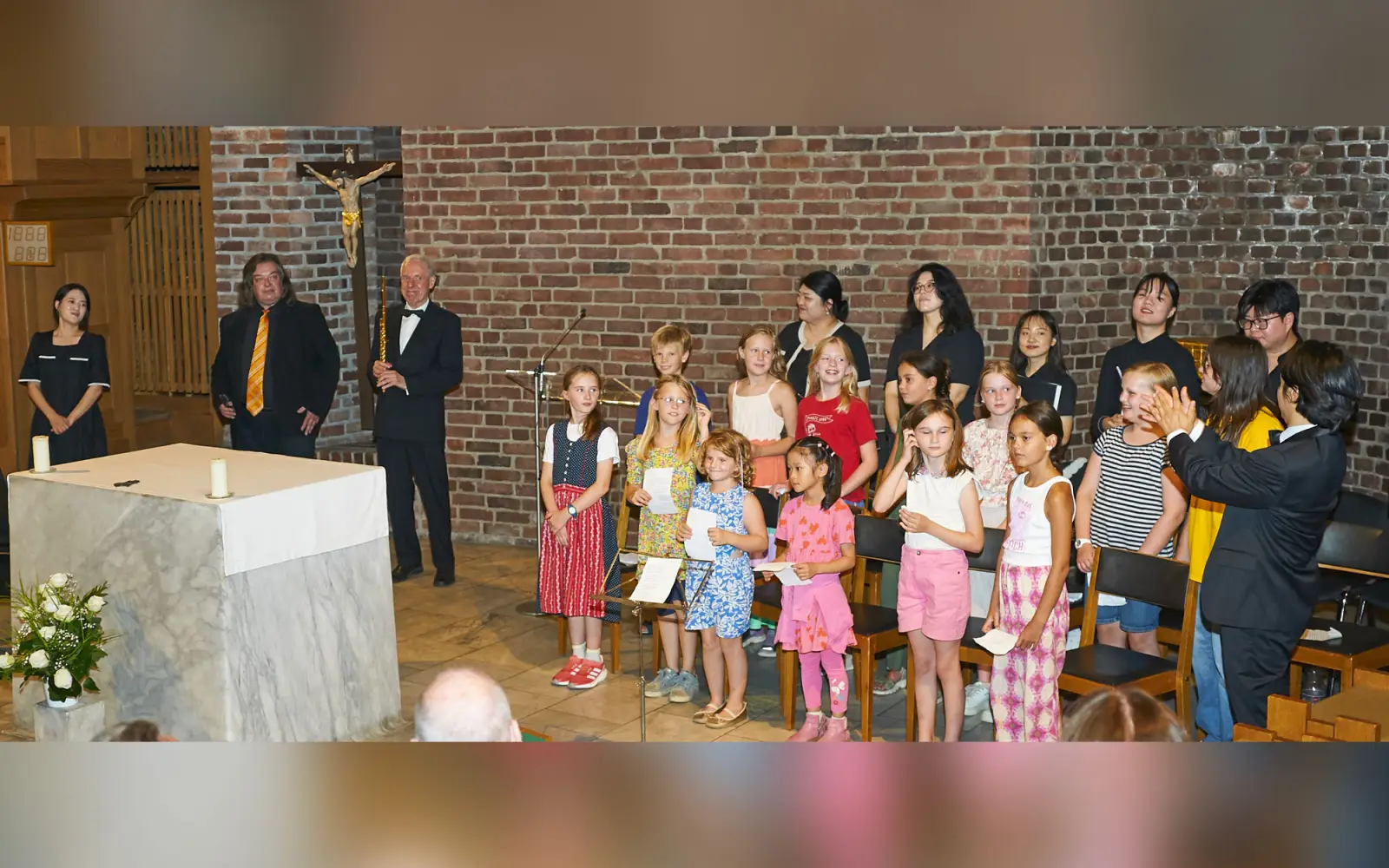 Das Abschlussbild (von links) Minhye Kim, Frank Scholzen und der 1. Vorsitzende des neuen Vereins, Johannes Kohlhaus, die beiden Chöre in der Mitte des Bildes sowie der Chorleiter Han Gyul Song, 2. Vorsitzender (ganz rechts), applaudierend. Foto: Mar