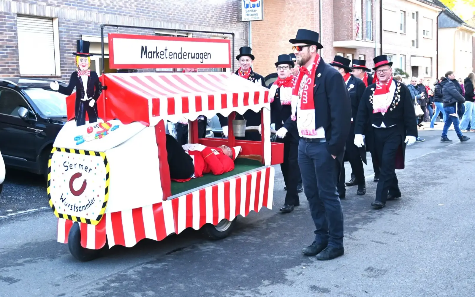 Der schlafende Hoppeditz wird am Sonntagmorgen (10. November) über die Dorfstraße gefahren, begleitet von zahlreichen Karnevalisten. Archivfoto: sam