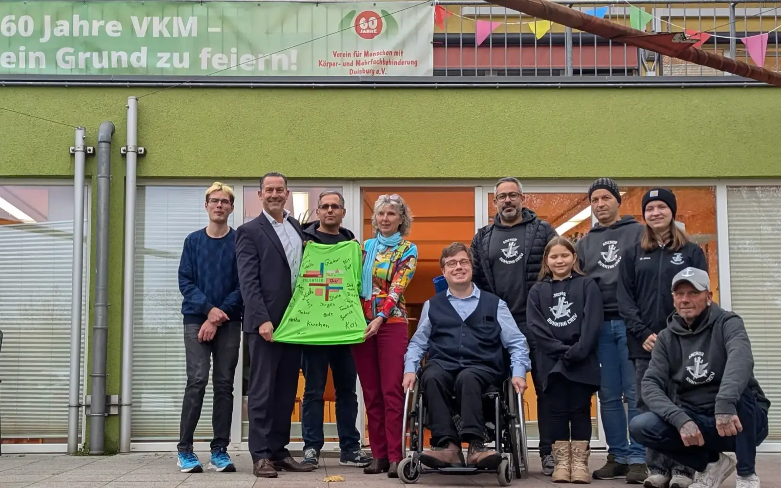 Mitglieder der Anchor Running Crew Duisburg und Vertreter des VKM Duisburg präsentieren das signierte Volunteer-Shirt. Von links: Malte Käbe (Öffentlichkeitsarbeit VKM), Emanuel Sageb (Anchor Running Crew), Anette Käbe (Vorstand VKM), Thomas Bienen (