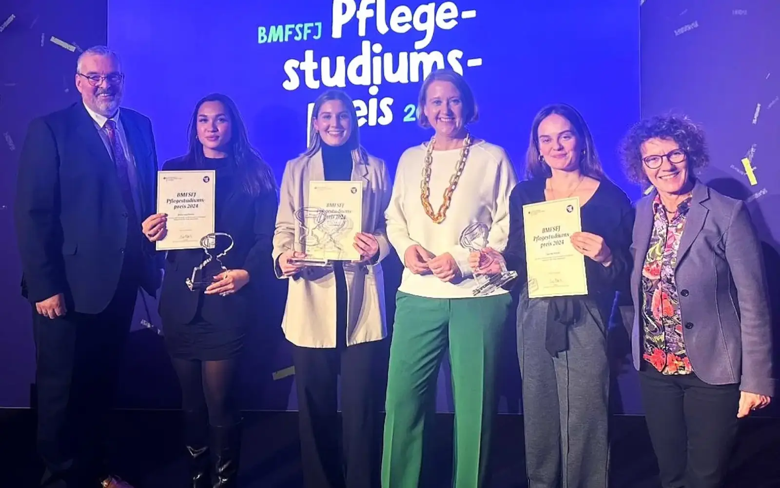 Die drei Düsseldorfer Gewinnerinnen Maria Kostian (zweite von links), Joy Schillinger (dritte von links) und Courtney Kleindt (fünfte von links) mit Studiengangsleiter Wolfgang Pasch (erster von links), Bundesfamilienministerin Lisa Paus (vierte von 