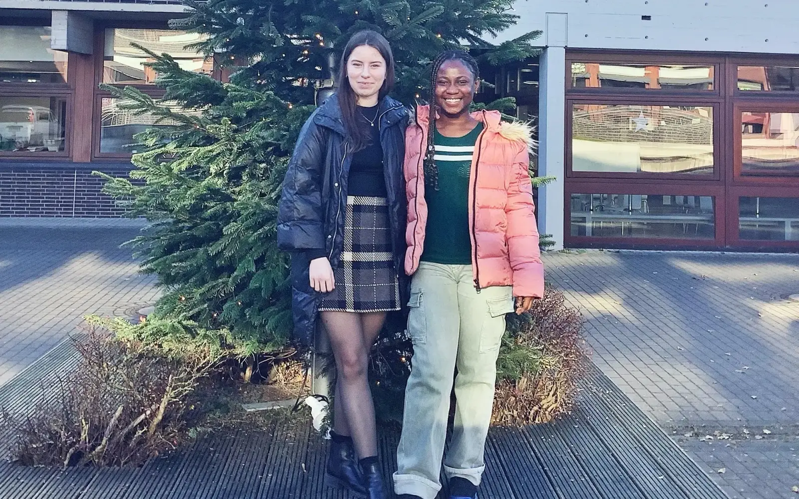 Faith und Mariia vor dem Weihnachtsbaum auf dem Schulhof des Theodor-Fliedner-Gymnasiums, wo sie über ihre Erfahrungen in den internationalen Klassen berichten. Foto: kh