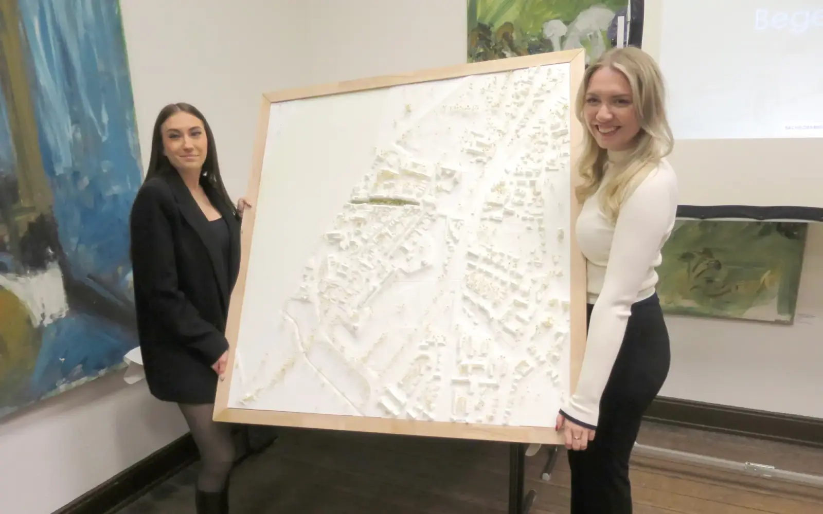 Diana Zimin und Carla Heller (von links) mit einem von ihnen angefertigten Stadtmodell, welches sie dem Heimat- und Bürgerverein Kaiserswerth überließen. Foto: hs