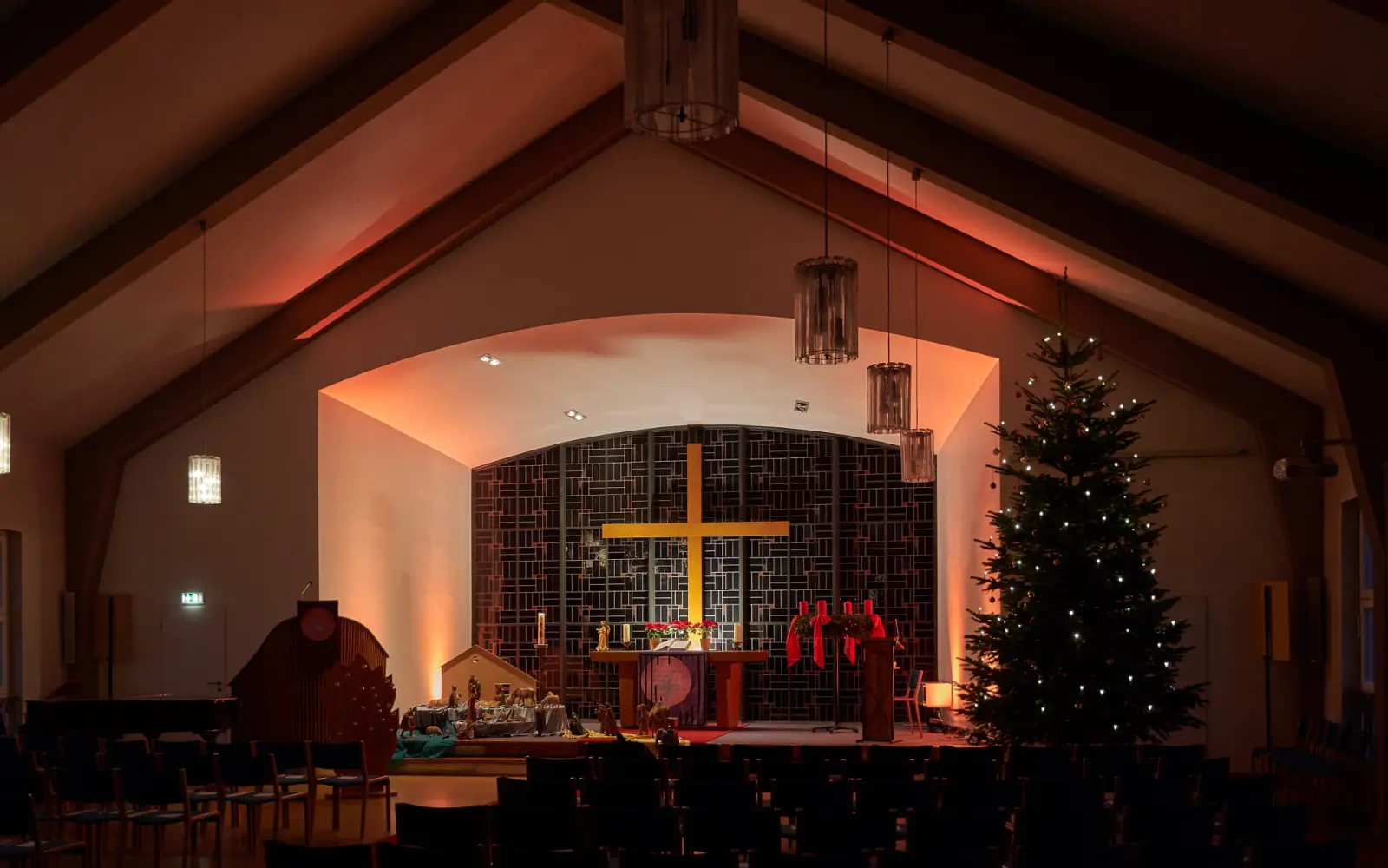 Die weihnachtlich beleuchtete Evangelische Kirche Huckingen mit festlichem Schmuck und Krippenszene. Archivfoto: evgds.de