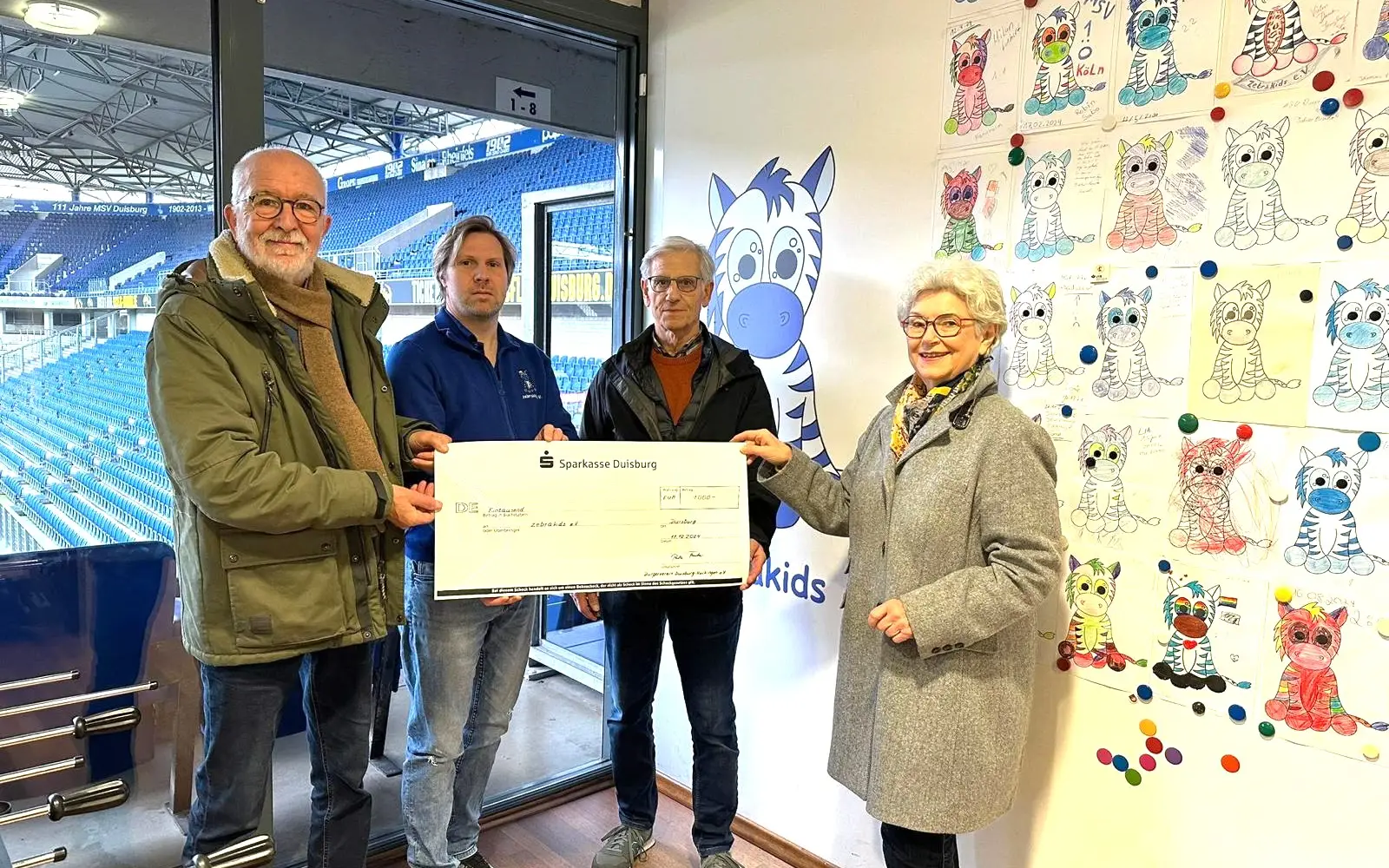 Bei der Spendenübergabe im MSV-Stadion (von links): Heinz Zielezinski, Carsten Labetzke (Zebrakids), Reiner und Rita Fischer. Foto: Bürgerverein Huckingen
