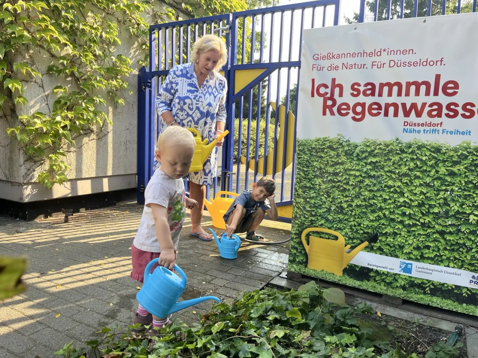 Kita-Leiterin Babette de Fries (mitte) ist stolz auf ihre Gießkannenhelden Lia und Miron, die sich vorbildlich für die Umwelt einsetzen. Foto: Kita