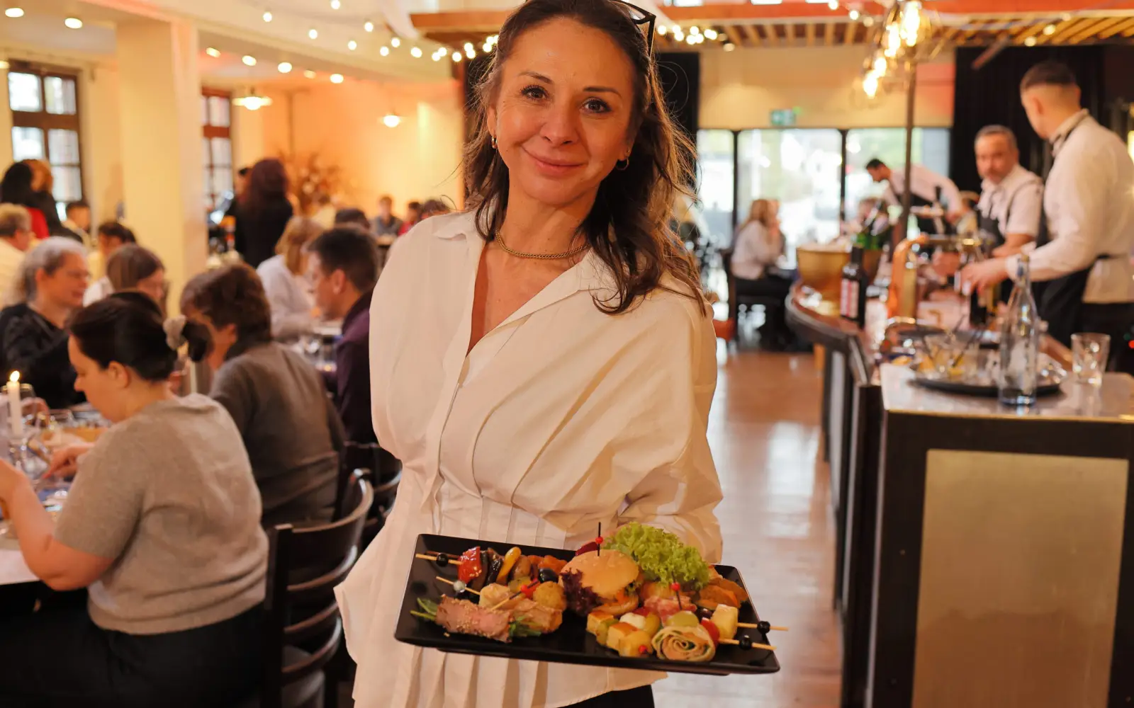 Geschäftsführerin Gabriele Ahrens präsentiert eine Auswahl an Vorspeisen und Fingerfood, wie sie beim Muttertagsbrunch in der Schlossallee 1 angeboten werden. Foto: Schlossallee 1