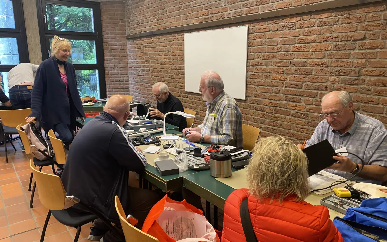 Im Reparaturcafé Kaiserswerth nehmen sich erfahrene Tüftler an langen Tischen der mitgebrachten Geräte an, am Freitag, 3. Juli, öffnet es von 15 bis 18 Uhr im Evangelischen Gemeindezentrum. Foto: privat