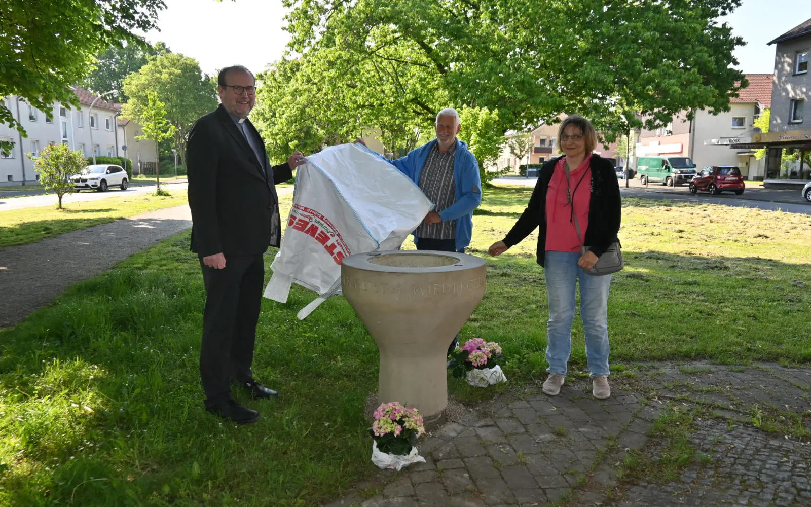 Enthüllten das Taufbecken an seinem neuen Ort, an dem ökumenischen Kreuz (von links): Pfarrer Andreas Brocke, Joachim Gierke und Sabine Lindner. Foto: sam