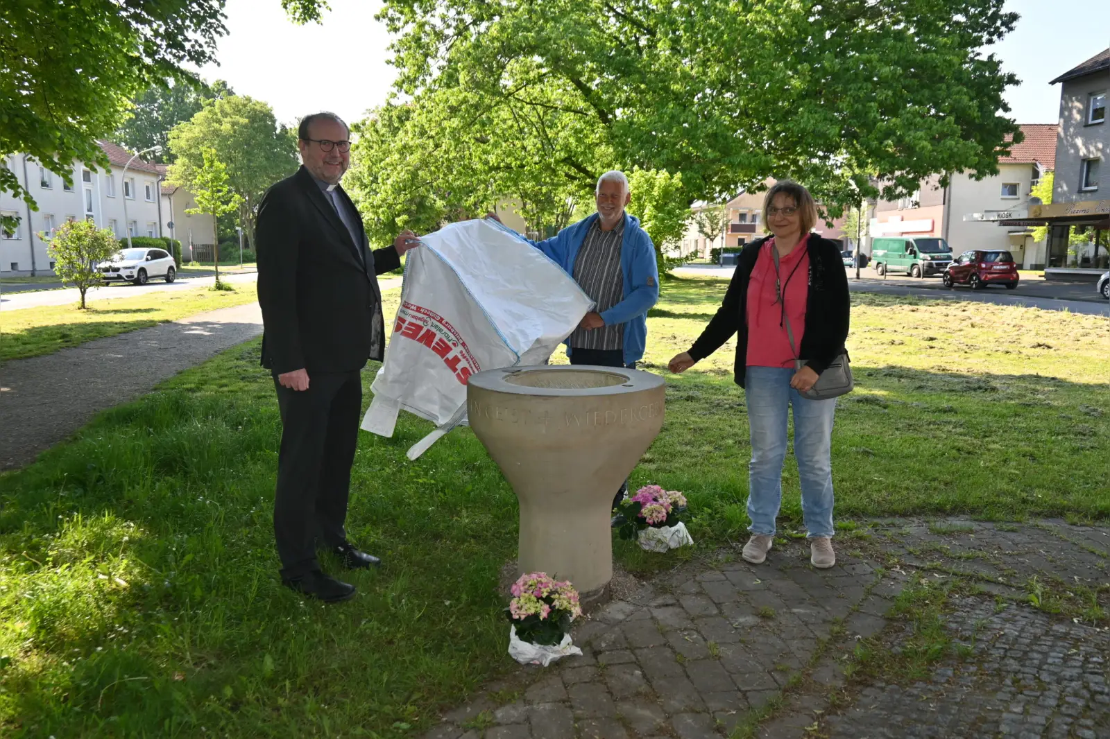 Enthüllten das Taufbecken an seinem neuen Ort, an dem ökumenischen Kreuz (von links): Pfarrer Andreas Brocke, Joachim Gierke und Sabine Lindner. Foto: sam