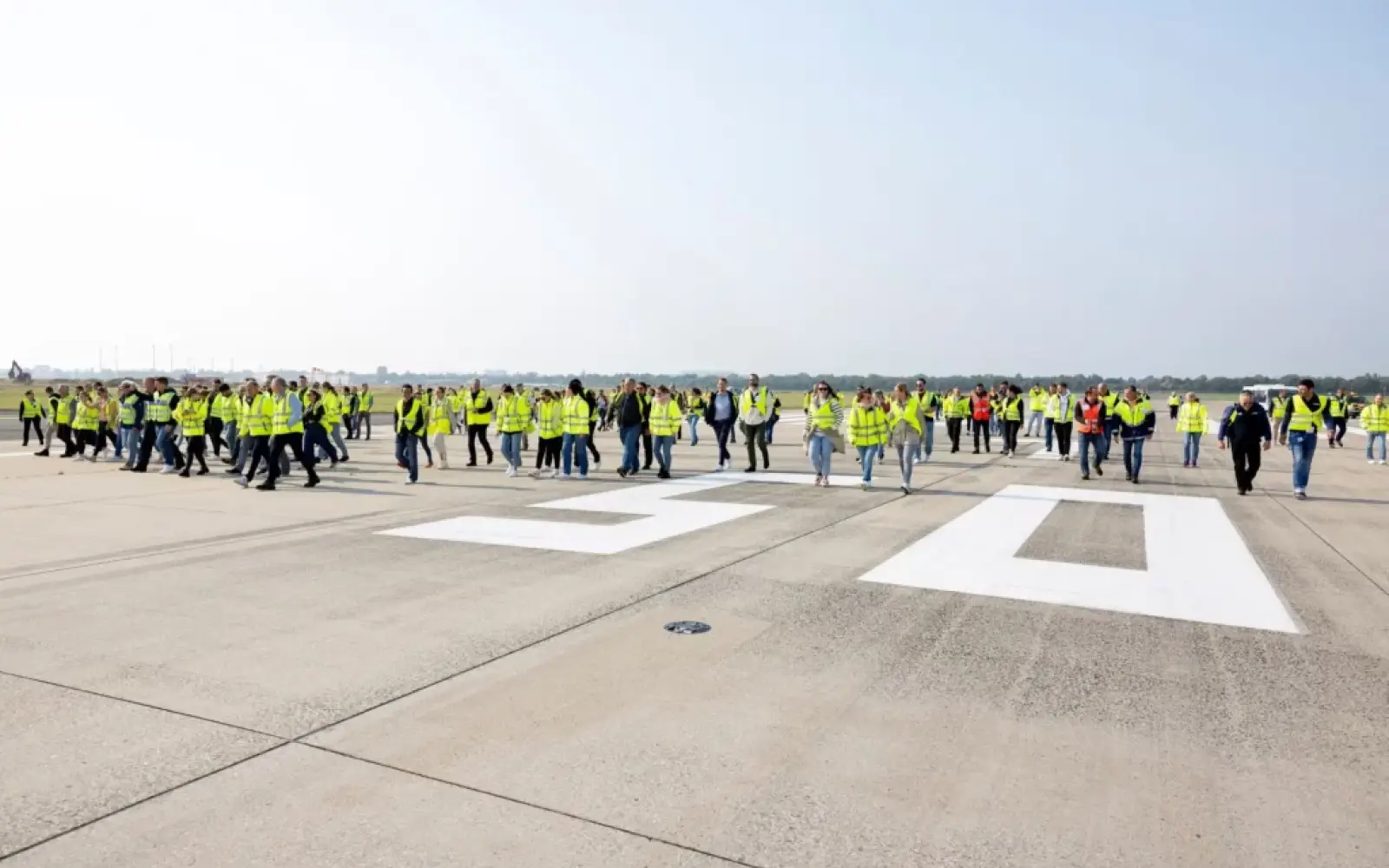 Die Teilnehmer des FOD-Walks durchsuchen die Rollbahn nach Fremdkörpern, um die Sicherheit zu erhöhen. Foto: Flughafen Düsseldorf / Andreas Wiese