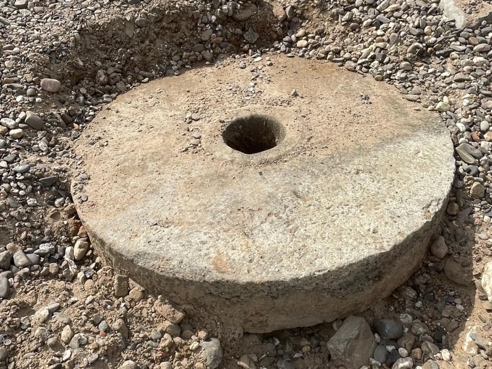 Etwa 1,35 Meter Durchmesser und geschätzt 800 Kilogramm Gewicht hat der alte Mühlstein, der im trockenen Rheinbett unterhalb des Zollhauses gefunden wurde. Foto: Karl Döhler