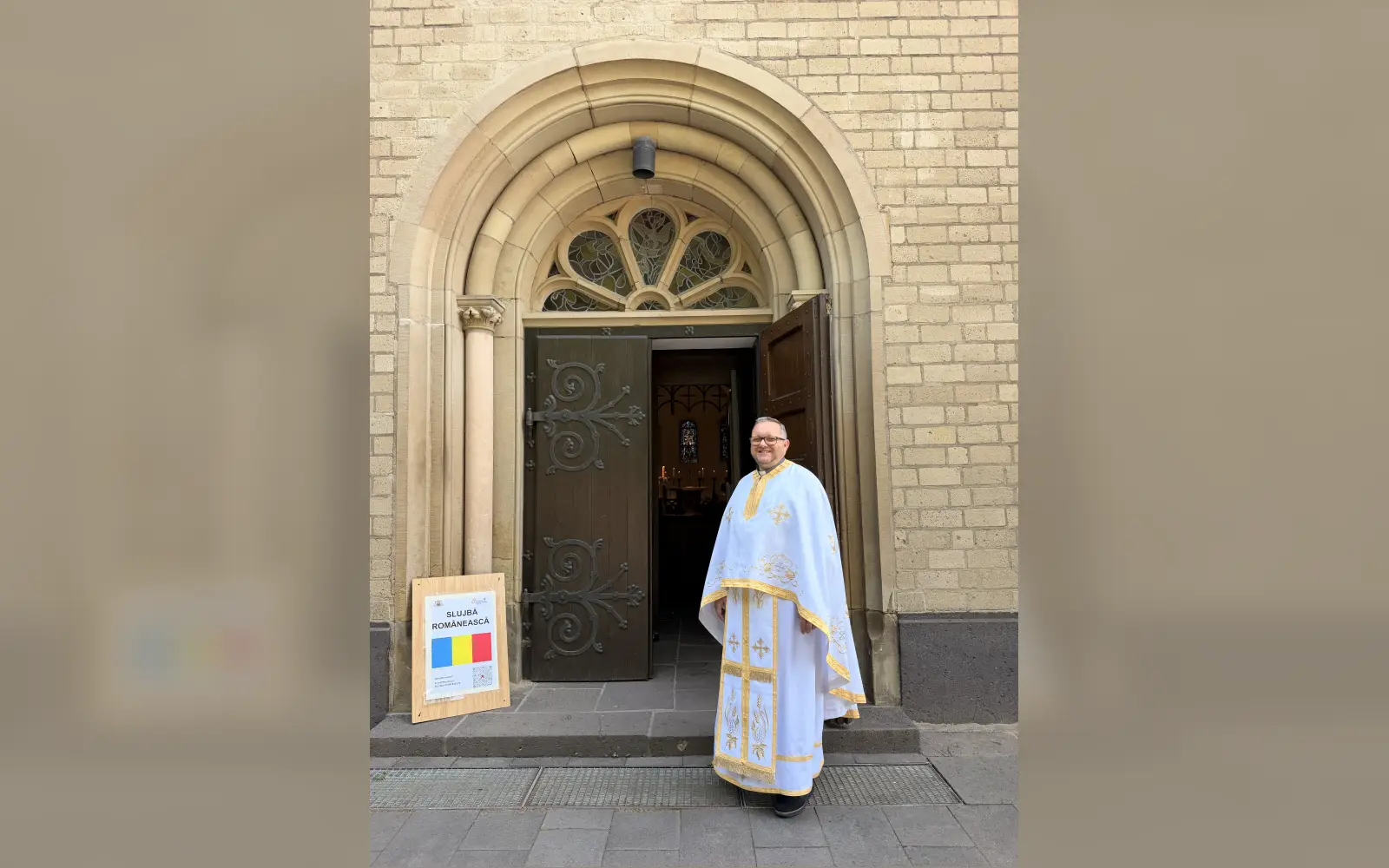 Das Schild „Slujbă Românească“ am Kirchenportal kündigt den rumänischen Gottesdienst an, den Pfarrer Mihai Suciu für die Gläubigen in den Erzbistümern Köln und Paderborn und im Bistum Essen feiert. Foto: Rumänische Griechisch-Katholische Gemeinde