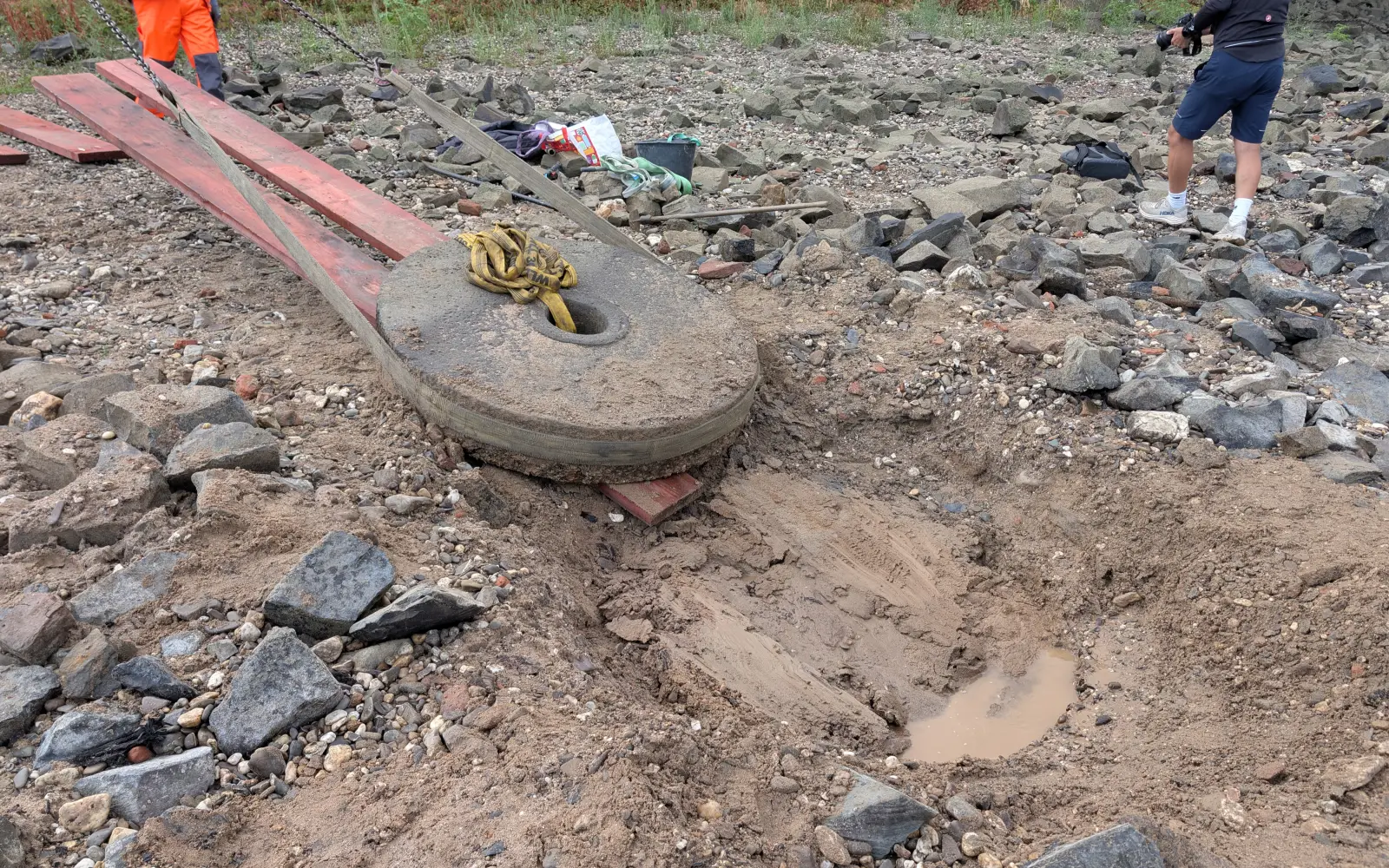 Über rote Holzbohlen zogen die Helfer den mit Gurten gesicherten Mühlenstein aus seiner Fundgrube. Foto: ah
