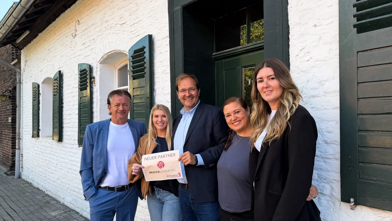 Arno Eich, Stefanie Link, Lars Wessel, Katharina Fütterer und Jessica Berrish (von links) besiegeln die Catering-Partnerschaft vor dem Steinhof in Huckingen. Foto: Steinhof Duisburg