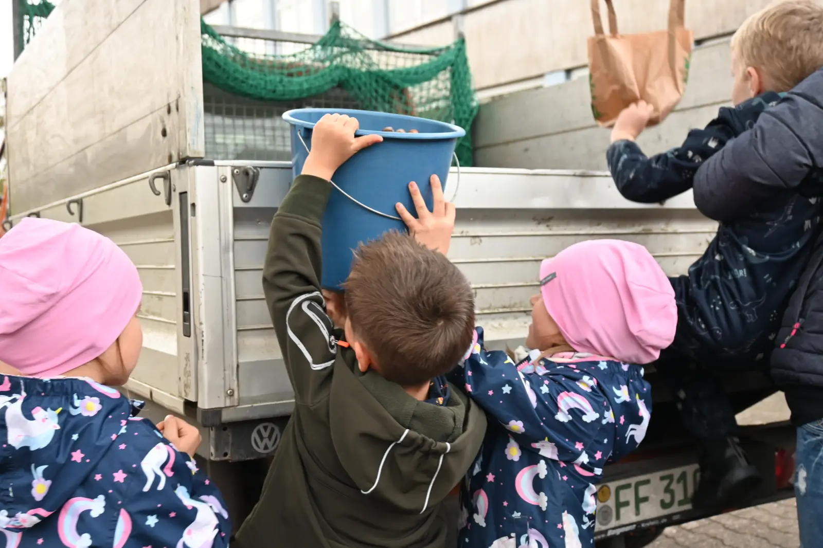 Mit vereinten Kräften luden die Kinder die Früchte auf den Transporter. Foto: sam