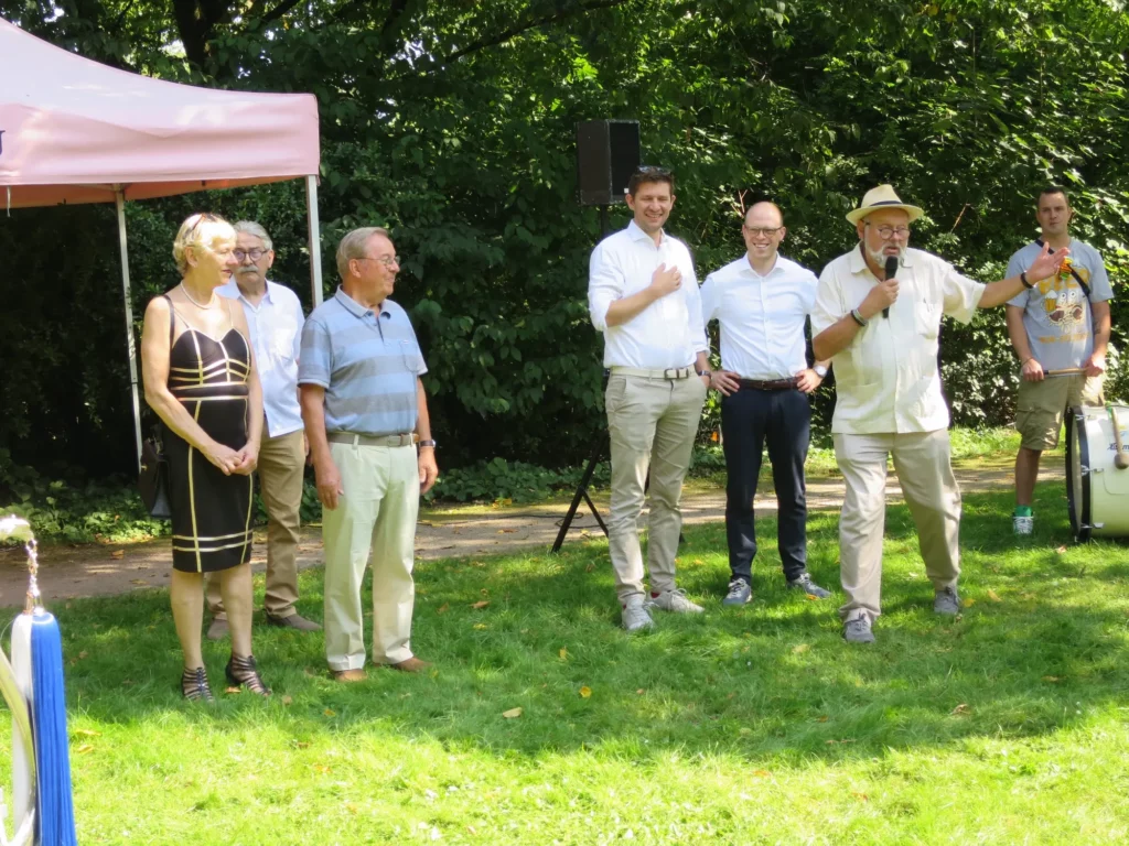 Zu Beginn des Festes stellten sich vor (von links): Dr. Dr. Marianne Hagen und Jürgen Gocht (Mitglieder der Bezirksvertretung), Siegfried Küsel, Fabian Zabel, Bezirksbürgermeister Benedict Stieber und Michael Riemer. Rechts ist ein Mitglied des Tambourcorps zu sehen. Foto: hs