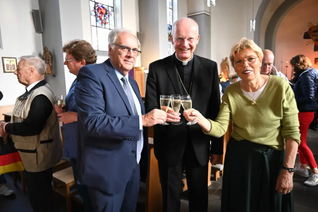 Mit einem Glas Sekt stießen Michel Germ, Ruhr-Bischof Dr. Franz-Josef Overbeck und Marlies Schmitz (von links) auf die neuen Eigentümer des Kirchorts Serm an. Foto: sam