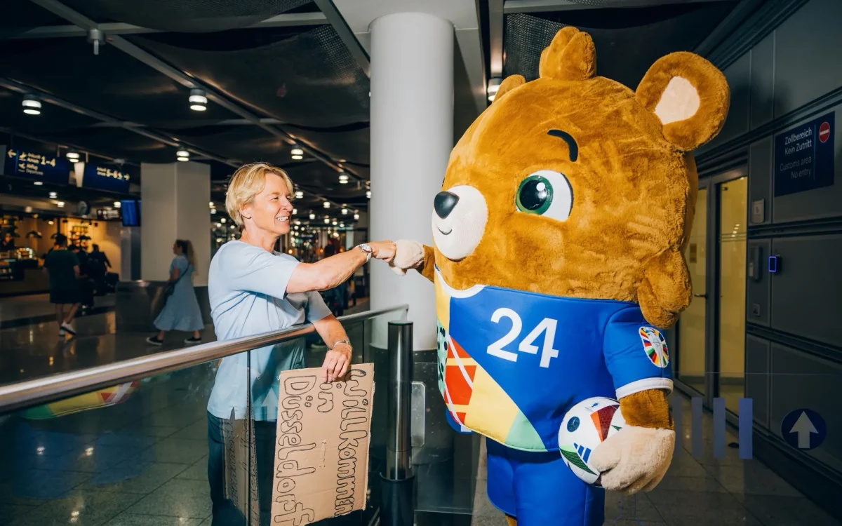 Die Düsseldorfer Botschafterin Martina Voss-Tecklenburg nimmt Maskottchen Albärt am Flughafen in Empfang © Visit Düsseldorf/Dominik Asbach